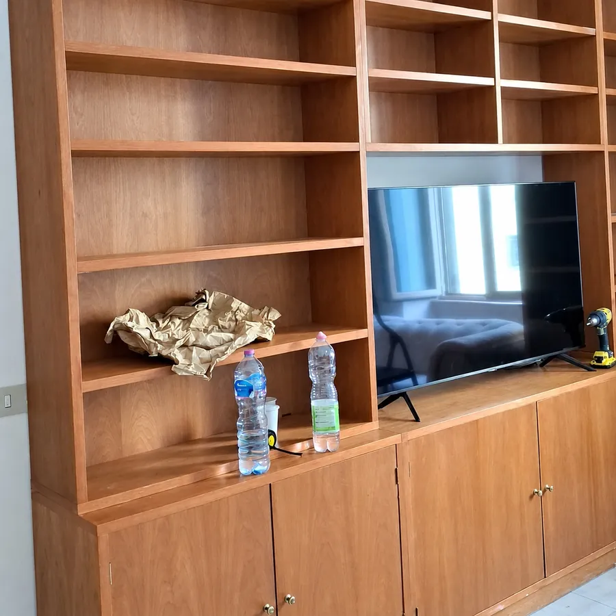 Libreria in legno con il televisore, rimontata nel soggiorno